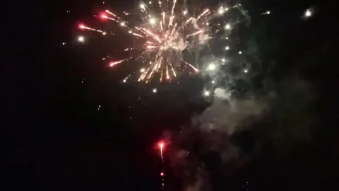 Colorful fireworks explosion display in the dark night sky with smoke Video stock 333636313
