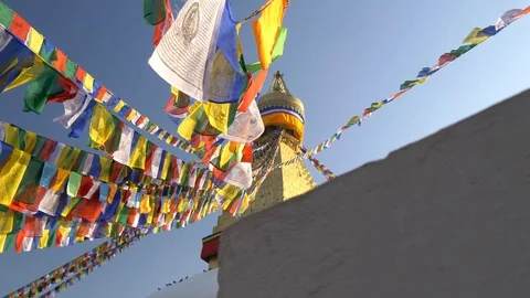 Colorful flags with Buddhist scriptures inscribed on them hanging tied to the Stock Footage 107877319