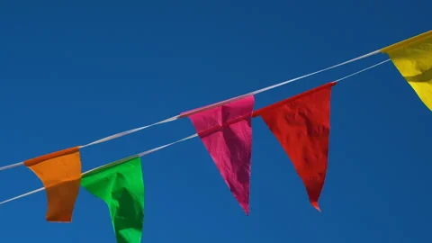 Colorful flags hanging on background of blue sky as festive decoration for Stock Footage 247472904