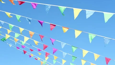 Colorful flags hanging on the background of blue sky as festive decorations for Stock Footage 276408846