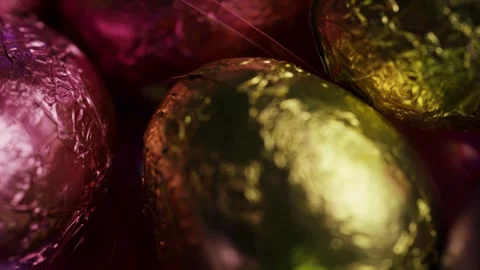 Colorful foil wrapped chocolate easter eggs rotating close up Stock Footage 328074748