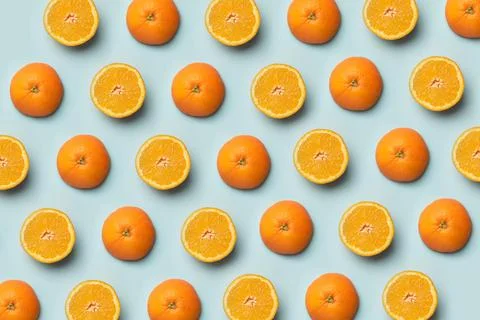 Colorful fruit pattern of fresh orange slices on blue background. Stock Photos