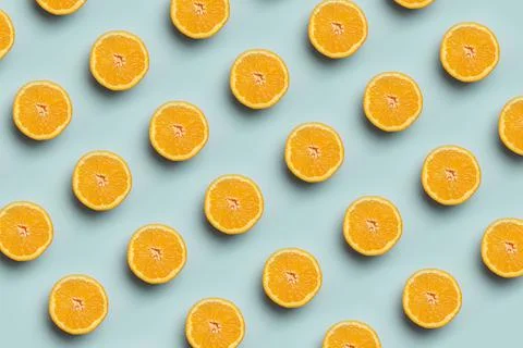 Colorful fruit pattern of fresh orange slices on blue background. Stock Photos