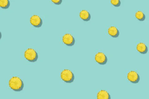Colorful fruit pattern of pineapples sliced on green background with shadow. Top Foto stock