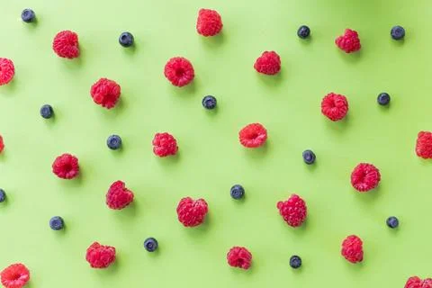Colorful fruit pattern of wild berries on green background. Raspberries Stock Photos