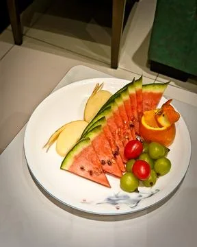 A colorful fruit platter featuring triangular slices of fresh watermelon, thin a 写真素材