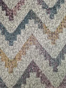 Colorful geometric zigzag pattern rug on a grey speckled base with shades o.. Stock Photos