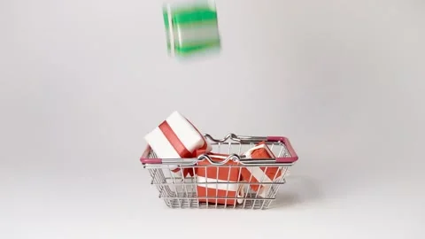 Colorful gift boxes fall down into shopping basket. Stock Footage 141947042