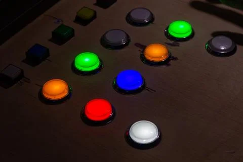 Colorful glowing push buttons on a control panel in dark room 写真素材