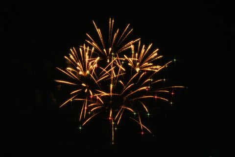 Colorful golden fireworks exploding across a dark night sky, creating a dyn.. Stock Photos