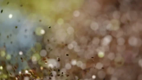 Colorful golden glitter particles exploding in slow motion, changing colors Stock Footage 293101687