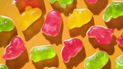 Colorful gummy candy ghosts top view on yellow background Stock Footage 345970439