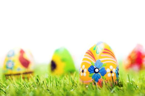 Colorful hand painted Easter eggs in grass. Spring theme, white copy-space 스톡 사진