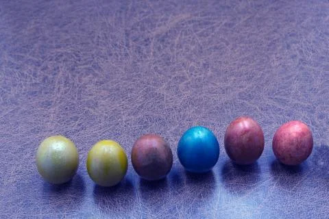 Colorful hand painted easter eggs in a row on old shabby wood for a backgroun Stock Photos