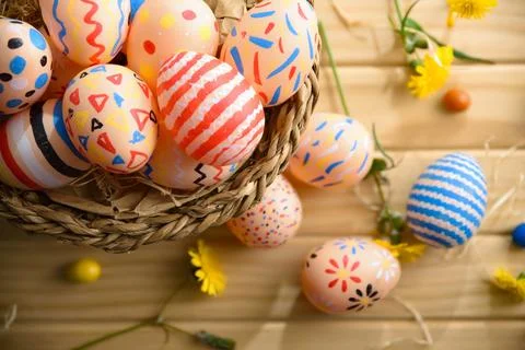 Colorful Hand-Painted Easter Eggs in Wicker Basket 库存照片