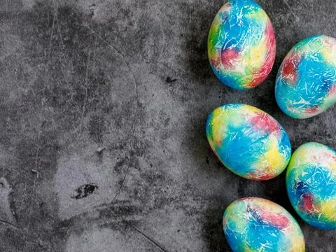 Colorful handmade Easter eggs painted like Earth on black marble background with Stock Photos