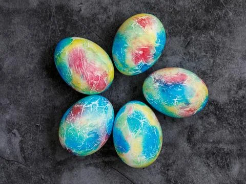 Colorful handmade Easter eggs painted like Earth on black marble background.. Stock Photos