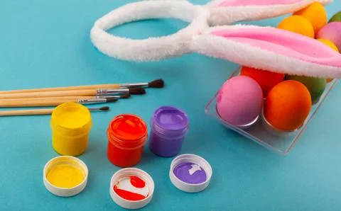 Colorful handmade Easter eggs, rabbit ears to play with, and jars of Stock Photos