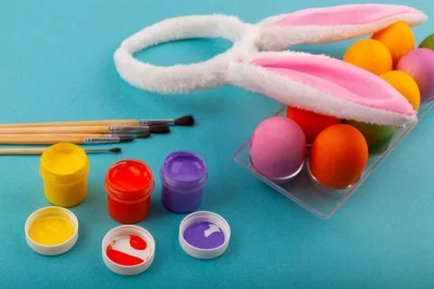 Colorful handmade Easter eggs, rabbit ears to play with, and jars of Stock Photos