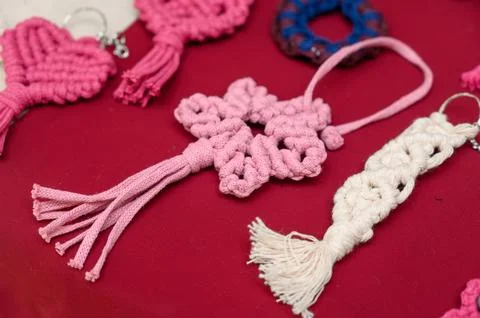 Colorful handmade macrame keychains displayed on red background Stock Photos