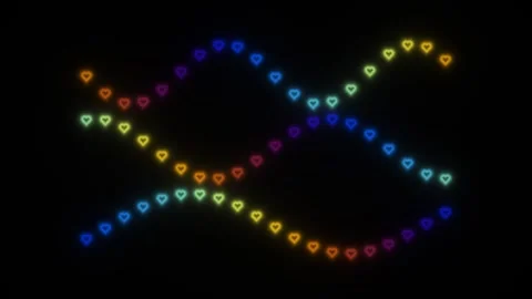 Colorful heart shapes in a wavy pattern on a dark Stock Footage 338235115