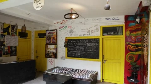 Colorful Hostel Reception Interior With Handwritten Messages and Yellow Doors Stock Footage 345688668