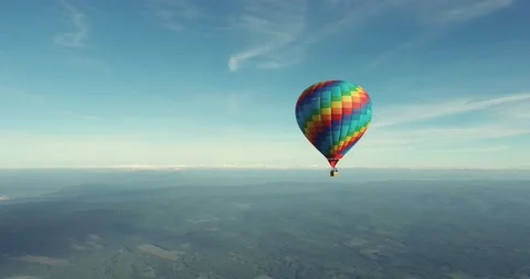 Colorful hot air balloon epic flying above mountain over the fog at sunrise Stock Footage