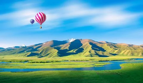 Colorful hot-air balloon flying over river Stock Photos