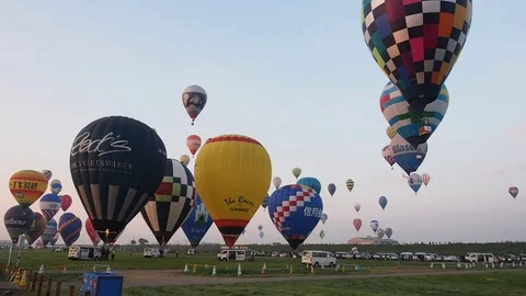 Colorful hot air balloons taking off at dawn Stock Footage