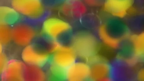 Colorful hydrogel balls rotating in water Stock Footage