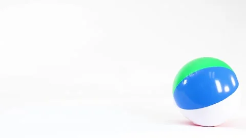 Colorful Inflatable Beach Ball Bouncing and Rolling on White Background Stock Footage 332831056