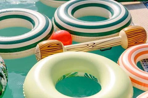 Colorful inflatable pool floats and toys in clear water 스톡 사진