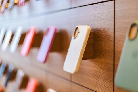 Colorful iPhone 16 Cases Displayed on Wooden Wall Stock Photos
