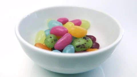 Colorful jelly beans candy, falling from above into white bowl. Slow motion. Stock Footage 134504450