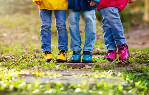 Colorful kids shoes. Children play outdoor. Stock Photos