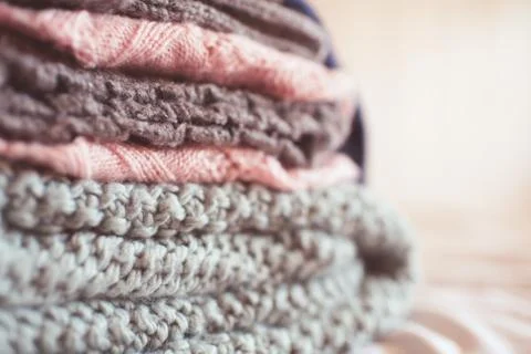 Colorful knitted clothes floded closeup. Winter season. Selective focus. Stock Photos