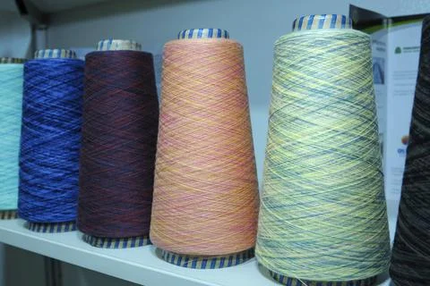 Colorful knitted thread spools put on a shelf at a shop Stock Photos