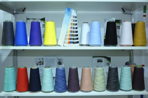 Colorful knitted thread spools put on a shelf at a shop Stock Photos