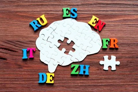 Colorful Language Codes Surround a Partially Completed Brain Puzzle 스톡 사진