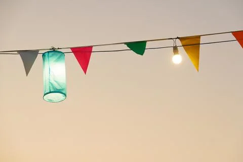 Colorful lanterns and flags create festive atmosphere at sunset Stock Photos