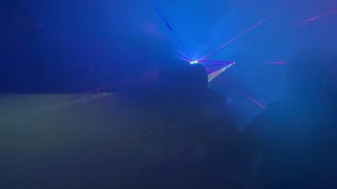 Colorful laser lights create dynamic visual effects in darkened environment Stock Footage 338264286
