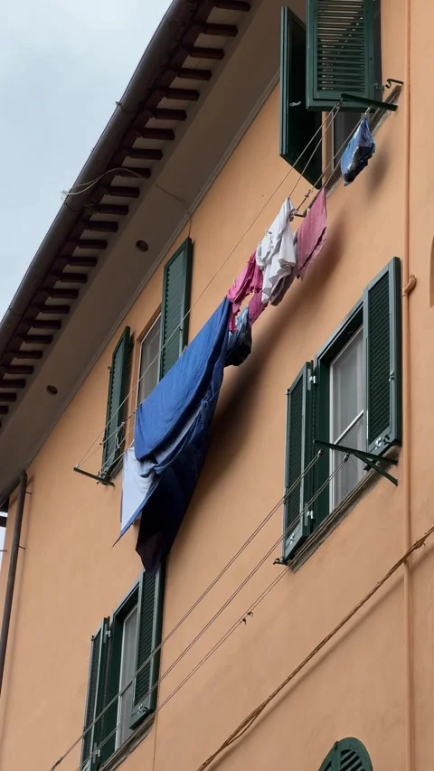 Colorful laundry hanging between windows on traditional building in Pisa, Italy Stock Footage 306959849