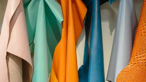 Colorful leather sheets hanging vertically in a workshop Stock Photos
