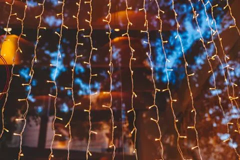 Colorful led string lights hanging in dark night scene Stock Photos