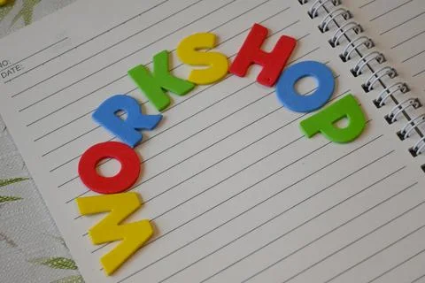 Colorful letters spelling workshop on a lined notebook Stock Photos