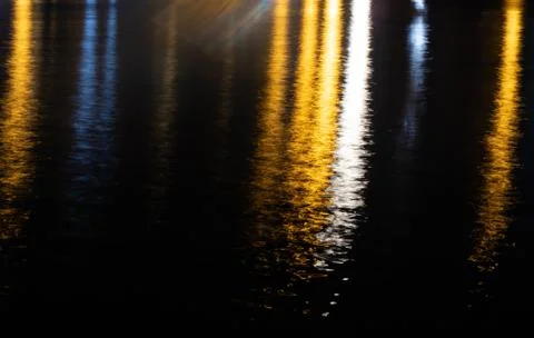 Colorful light reflection on the water surface at night. Stock Photos