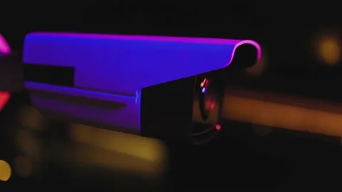 At colorful light security video camera surveillance moving to scan the area at Stock Footage 151115403