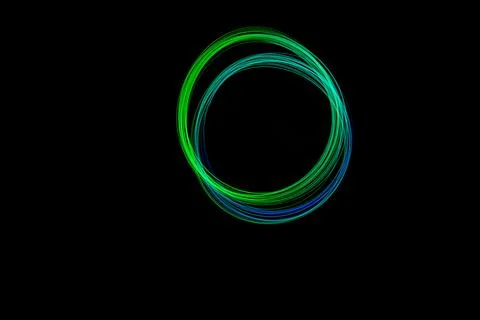 Colorful light trails form a perfect circle against a dark background, show.. Stock Illustration