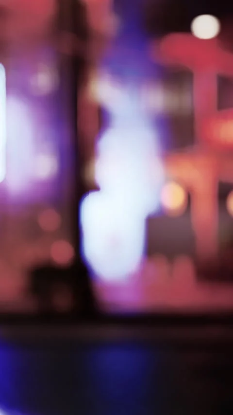 Colorful lights create a vibrant atmosphere in a busy city street at night Stock Footage 335690316