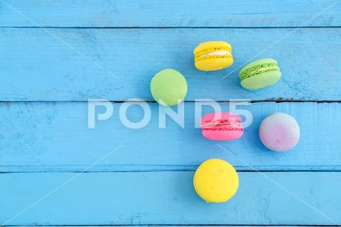 Colorful macaroni or macaroons cookies on blue wooden vintage background. top Stock Photos